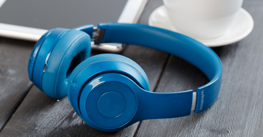 Employee wearing over ear wireless headset seated at modern office desk