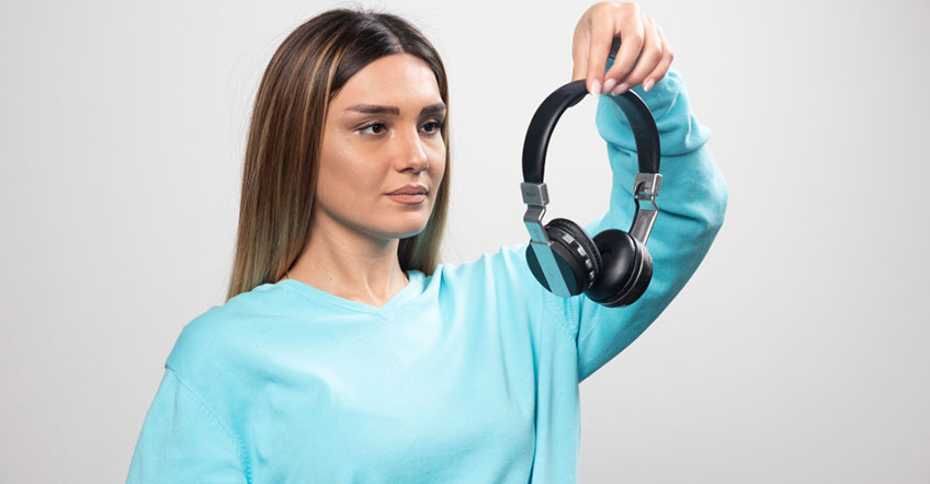 Customer service agent adjusting wireless headset while working at office desk